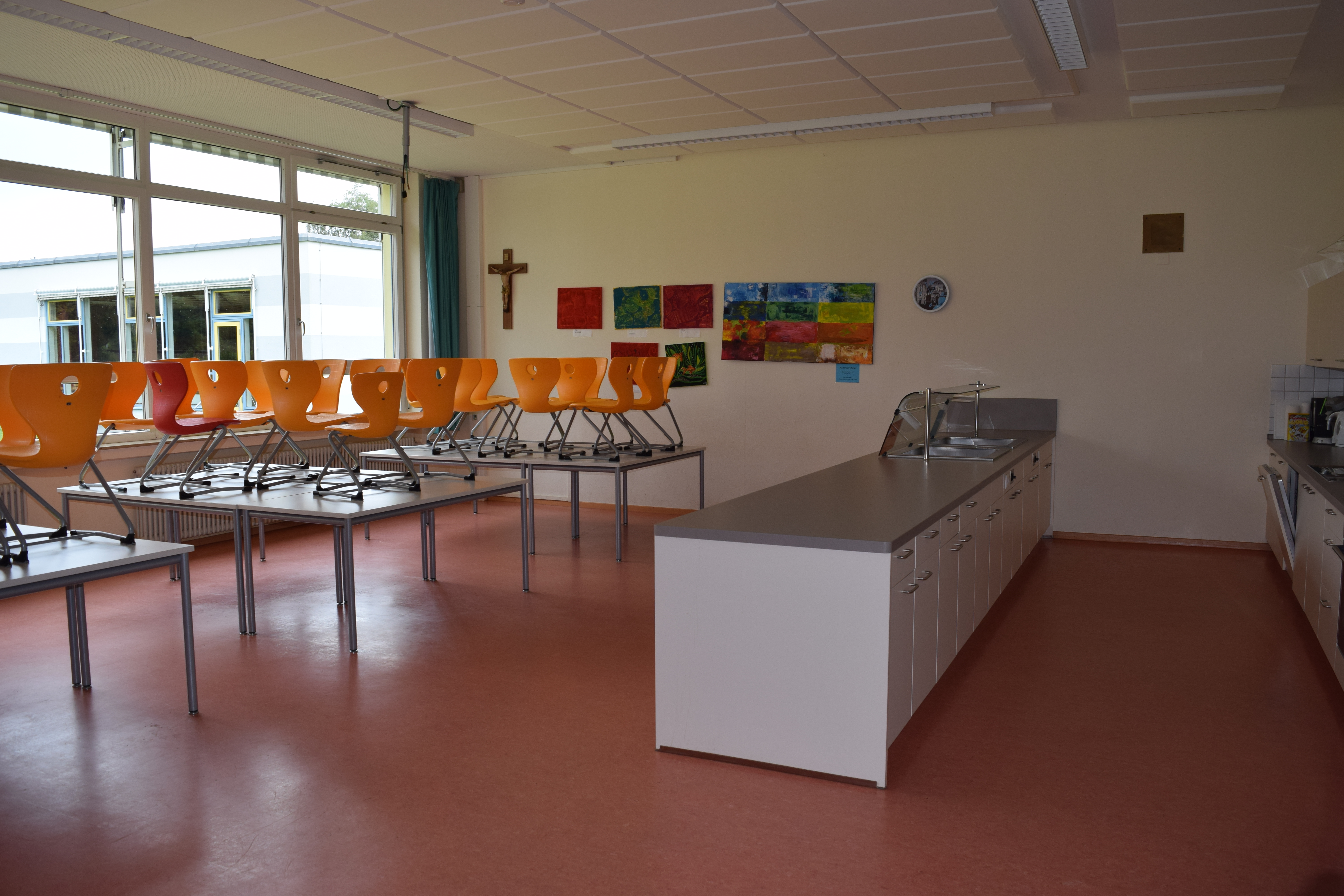 Bild der Mensa mit Stühlen auf den Tischen, ohne Schüler und Mitarbeiter.